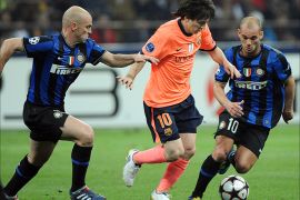 epa02125478 FC Barcelona's Lionel Messi (C) fights for the ball with Inter Milan Wesley Sneijder (R) and Esteban Cambiasso (L) during the Champions League semi final, first leg, soccer match, Inter Milan vs FC Barcelona, held at the Meazza stadium, in Milan, Italy on 20 April 2010. EPA/DANIEL DAL ZENNARO