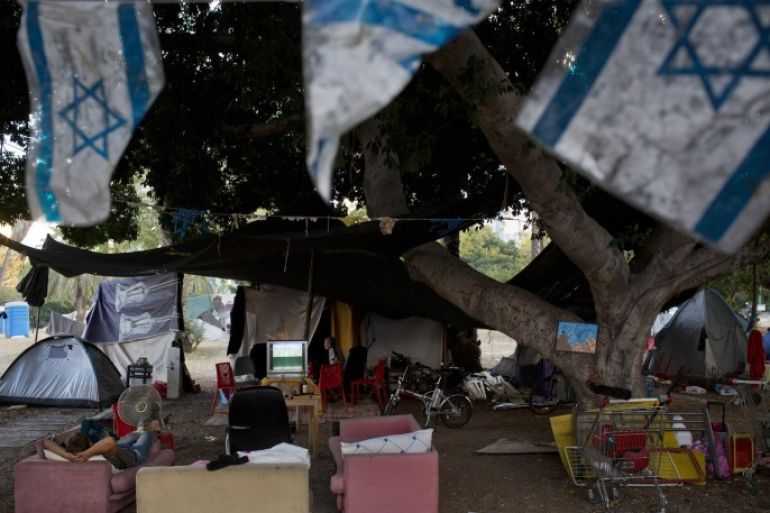 An Israeli homeless man sleeps on a sofa outside his tent where other homeless live for a couple of years, in a public park in the center of Tel Aviv, Israel, Tuesday, June 24, 2014. Israel on Tuesday joined an influential group of rich nations that help poor indebted economies, giving the country an international boost of recognition for its economic accomplishments. The news that Israel had been accepted into the Paris Club of creditor nations was welcomed by Israeli policy makers, who are facing calls to reduce high levels of poverty and inequality even as the country’s economy appears to be humming along. (AP Photo/Oded Balilty)