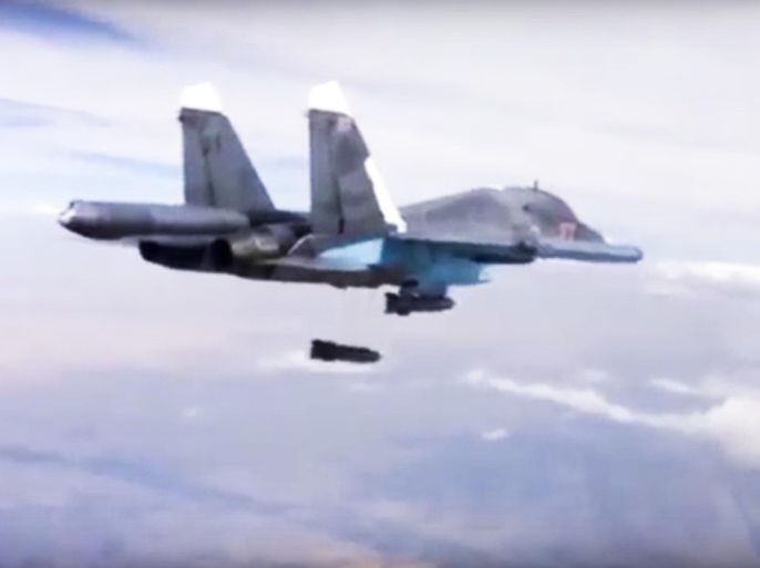 In this photo made from video footage provided by the Russian Defense Ministry on Wednesday, Dec. 9, 2015, a Russian Su-34 bomber drops bombs on a target. Russia has unleashed another barrage of airstrikes against targets in Syria, including the first combat launch of a new cruise missile from a Russian submarine in the Mediterranean Sea, the country's defense minister said Tuesday. (Russian Defense Ministry Press Service via AP)