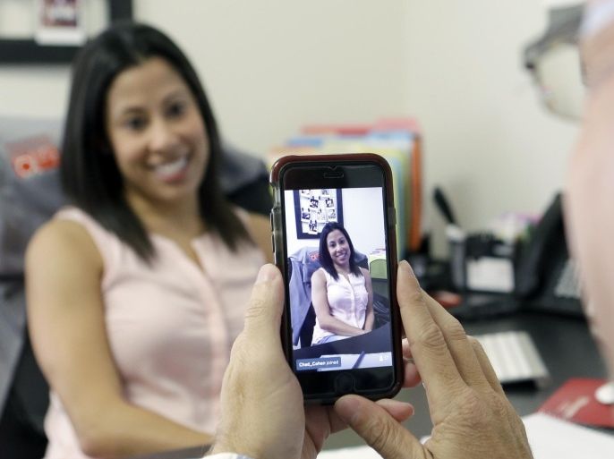 In this June 29, 2015, photo, Lauren Simo, left, answers questions during a weekly forum streamed via Periscope on the smartphone of Fish Consulting director of social media Toby Srebnik, at the company's offices in Hollywood, Fla. Marketing successes with Facebook, Twitter, Pinterest and Instagram have encouraged companies to try streaming apps like Periscope and Meerkat. (AP Photo/Alan Diaz)