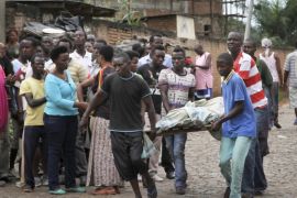 Men carry away a dead body in the Nyakabiga neighborhood of Bujumbura, Burundi, Saturday, Dec. 12, 2015. Burundi's political violence continued Saturday as a number of people were found shot dead in the Nyakabiga neighborhood of the capital, a day after the government said an unidentified group carried out coordinated attacks on three military installations. (AP Photo)