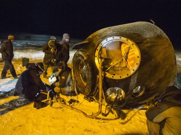 A search and rescue team works on the site of landing of the Soyuz TMA-17M capsule with the International Space Station crew near the town of Dzhezkazgan, Kazakhstan, Friday, Dec. 11, 2015. A three-person crew, U.S. space agency's Kjell Lindgren, Russia's Oleg Kononenko and Kimiya Yui of Japan, from the International Space Station landed safely Friday in the snowy steppes of Kazakhstan. (Andrey Shelepin/Pool Photo via AP)