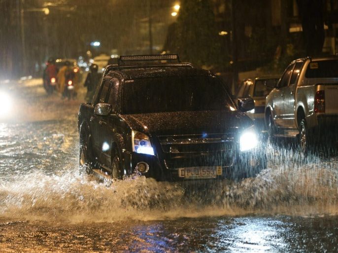 A vehicle drives down a flooded street as heavy rain pours in Makati city, south of Manila, Philippines, 15 December 2015. At least four people were killed and hundreds of thousands displaced as a powerful typhoon pummelled the Philippines for the second day, officials said. Typhoon Melor also toppled trees and electric posts, totally and partially destroyed houses, as well as submerging rice paddies in waters, according to the National Disaster Risk Reduction and Management Council (NDRRMC). Thousands of air and sea passengers were stranded in different ports and airports as 64 domestic flights were cancelled while hundreds of ships were stopped from sailing due to bad weather.
