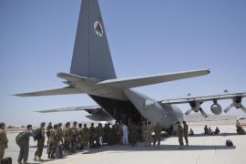 In this Tuesday, Aug. 18, 2015 photo, Afghan National Army soldiers line up to get into a C-130 Hercules, at Kandahar Air Base, in Kandahar, Afghanistan. A series of airports, built by NATO to fight the Taliban, are being handed over to the Afghan government in a civil aviation upgrade that optimists hope will fuel not only regional trade but even tourism. The eight airfields, worth an estimated $2 billion, are scattered around a landlocked and mountainous land whose lack of rail transport or decent roads makes almost every intercity journey a perilous adventure -- even without factoring in attacks from Taliban militants. (AP Photo/Massoud Hossaini)