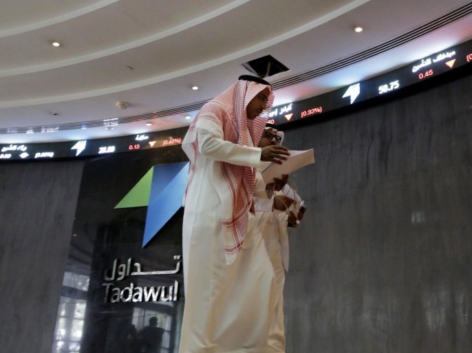 Saudi men walk at the Tadawul Saudi Stock Exchange, in Riyadh, Saudi Arabia, Monday, June 15, 2015. Saudi Arabia's stock market, valued at $585 billion, opened up to direct foreign investment for the first time Monday, as the kingdom seeks an economic boost amid low global oil prices. (AP Photo/Hasan Jamali)
