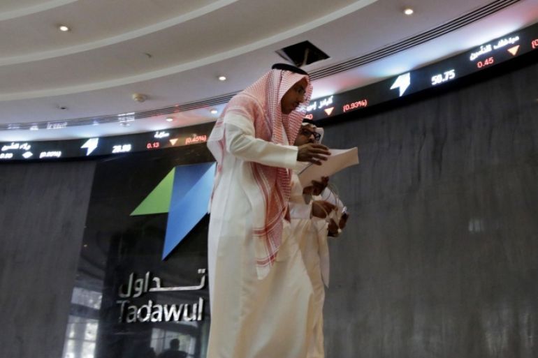Saudi men walk at the Tadawul Saudi Stock Exchange, in Riyadh, Saudi Arabia, Monday, June 15, 2015. Saudi Arabia's stock market, valued at $585 billion, opened up to direct foreign investment for the first time Monday, as the kingdom seeks an economic boost amid low global oil prices. (AP Photo/Hasan Jamali)