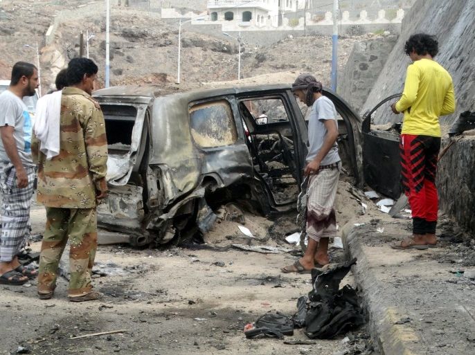 People look at the wreckage of a car at the site of the a car bomb attack that killed the governor of Yemen's southern port city of Aden December 6, 2015. Jaafar Mohammed Saad was killed on Sunday when a suicide bomber rammed his car into the governor's convoy in the western part of Aden city, residents and a local official said. REUTERS/Nasser Awad