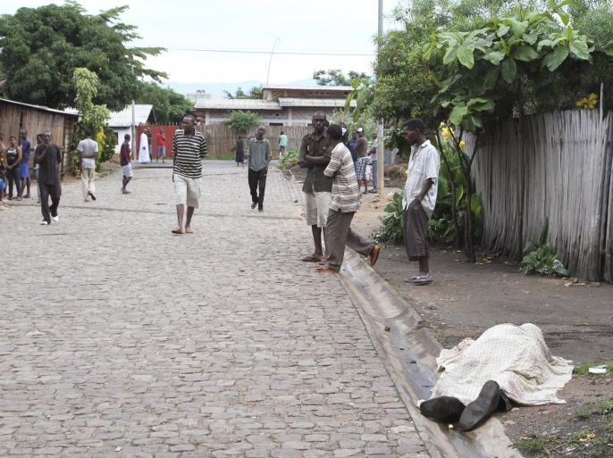 ATTENTION EDITORS - VISUAL COVERAGE OF SCENES OF INJURY OR DEATH Residents look at the covered body of an unidentified man killed during gunfire, in the Nyakabiga neighbourhood of Burundi's capital Bujumbura, December 12, 2015. At least 20 dead bodies were seen on the streets of the Burundian capital Bujumbura on Saturday, a police source said, following the worst outbreak of violence since a failed coup in May. REUTERS/Jean Pierre Aime HarerimanaTEMPLATE OUT