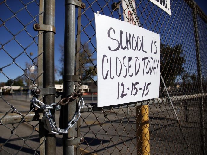 A gate to Birmingham Community Charter High School is locked with a sign stating that school is closed, Tuesday, Dec. 15, 2015, in Van Nuys, Calif. All schools in the vast Los Angeles Unified School District, the nation's second largest, have been ordered closed due to an electronic threat Tuesday. (AP Photo/Danny Moloshok)