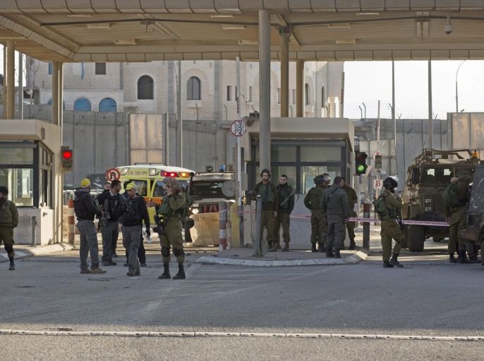 Israeli soldiers guarding the Qalandia checkpoint, leading from the West Bank to Jerusalem next to Palestinian vehicle used by an Arab terrorist who tried to run over soldiers at the checkpoint, on 18 December 2015. The Israeli army report, that the attacker was shot and wounded and no soldiers were injured.