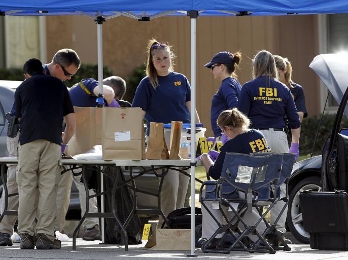 FBI agents gather evidence in front of the Redlands residence and vehicle belonging to the shooters in connection to the Wednesday massacre in San Bernardino, California December 3, 2015. Authorities on Thursday were working to determine why a man and a woman opened fire at a holiday party of his co-workers in Southern California, killing 14 people and wounding 17 in an attack that appeared to have been planned. REUTERS/Alex Gallardo