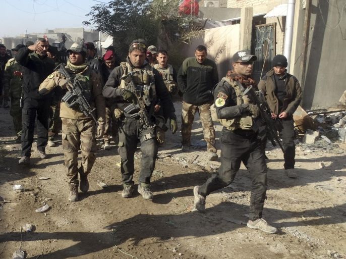 Iraqi security forces enter the government complex in central Ramadi, 70 miles (115 kilometers) west of Baghdad, Iraq, Monday, Dec. 28, 2015. Iraqi military forces on Monday retook a strategic government complex in the city of Ramadi from Islamic State militants who have occupied the city since May. (AP Photo/Osama Sami)