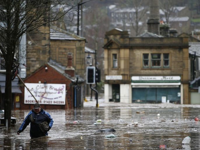 A man wades through flood waters at Hebden Bridge in West Yorkshire, England, Saturday Dec. 26, 2015. Parts of northwest England already hit hard by flooding in recent weeks were under severe flood warnings Saturday because of forecasts for more heavy rain, with some areas being evacuated. (Peter Byrne/PA via AP) UNITED KINGDOM OUT