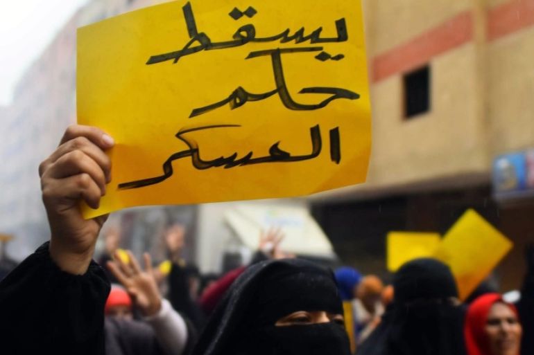 A Egyptian supporter of the former president Mohamed Morsi holding a sign in arabic that reads: ' Down with military rule' particpate in a protest in Alharam in Giza, Egypt, 25 January 2016, on the eve of the fifth anniversary of the 25 January uprising. Egyptians are planning protests to mark the 2011 uprising known as the Arab Spring will commit a 'crime' and must be punished, Minister of Religious Affairs Mohammed Mokhtar said earlier this month. The warning came after Egyptian secular activists and backers of the banned Muslim Brotherhood group called on Egyptians to hold massive anti-government protests on 25 January, which marks the anniversary of the revolt that toppled longtime dictator Hosny Mubarak.