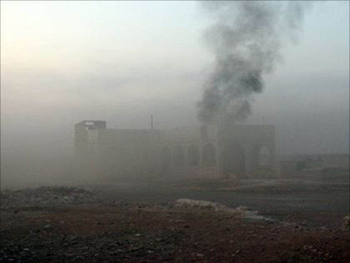أحد المنازل في ريف حلب الجنوبي وخلفه سحب الدخان جراء القصف الروسي (الجزيرة نت)