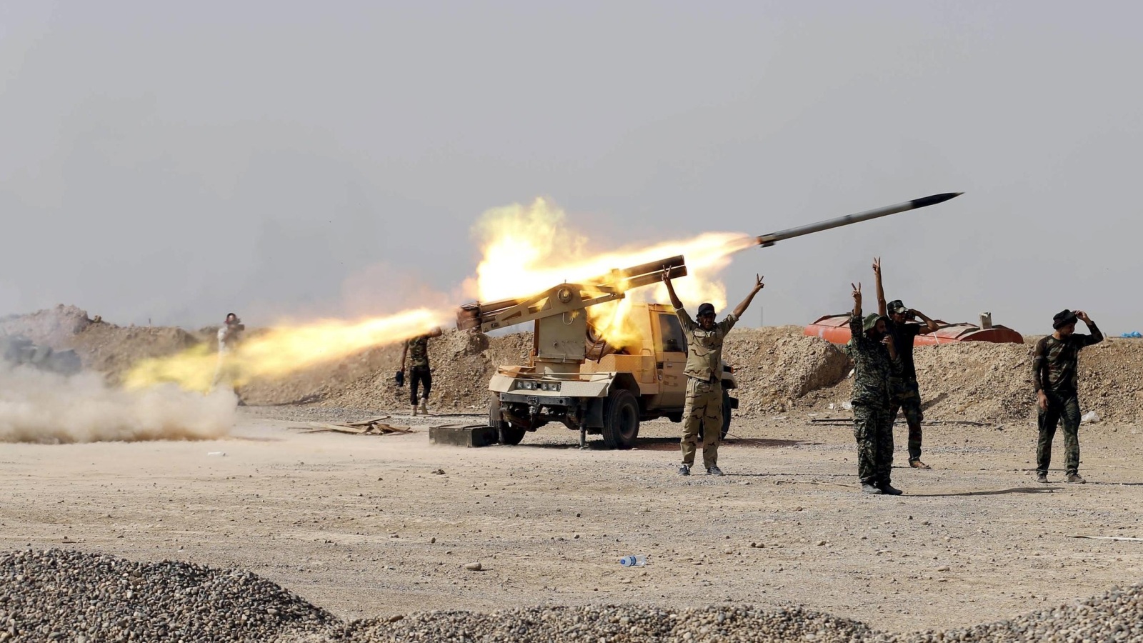 ‪مقاتلون من الحشد الشعبي يطلقون صاروخا على تنظيم الدولة بمنطقة بيجي‬ (رويترز-أرشيف)