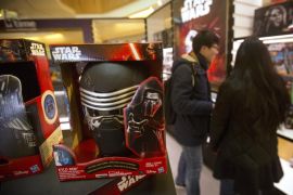 A couple looks at "Star Wars" merchandise for sale at a shopping mall in Beijing, Saturday, Jan. 9, 2016. The record-breaking "Star Wars" opened Saturday in China, where it is far from certain to draw in enough moviegoers to knock off "Avatar" as the world's all-time biggest grossing movie. (AP Photo/Mark Schiefelbein)