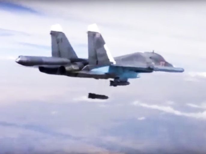 FILE - In this Dec. 9, 2015 file photo made from video footage provided by the Russian Defense Ministry, a Russian Su-34 bomber drops bombs on a target. A new report by a human rights watchdog group accuses Russia of using cluster munitions and unguided bombs on civilian areas in Syria in attacks that it says have killed hundreds of people. The report by Amnesty International released Wednesday, Dec. 23, 2015, says there has been a surge in reports of the use of cluster munitions in the areas being targeted by Russian forces since Moscow formally joined the conflict Sept. 30. (Russian Defense Ministry Press Service via AP, File)