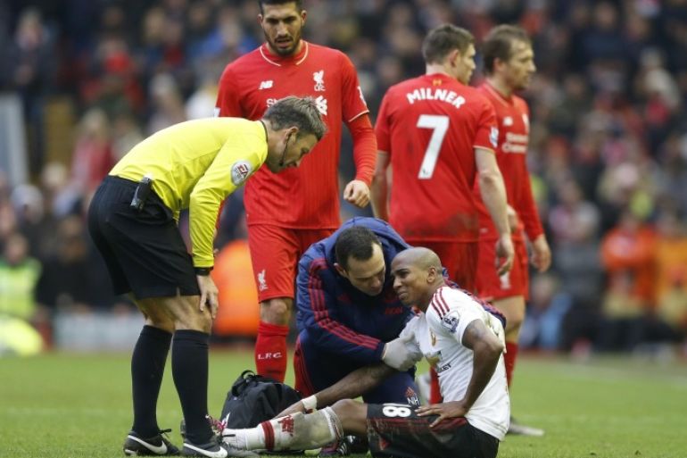 Football Soccer - Liverpool v Manchester United - Barclays Premier League - Anfield - 17/1/16 Manchester United's Ashley Young receives medical attention as referee Mark Clattenburg looks on Action Images via Reuters / Carl Recine Livepic EDITORIAL USE ONLY. No use with unauthorized audio, video, data, fixture lists, club/league logos or "live" services. Online in-match use limited to 45 images, no video emulation. No use in betting, games or single club/league/player publications. Please contact your account representative for further details.