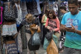 People shop in Sao Paulo, Brazil, Tuesday, Dec. 1, 2015. Latin America's largest economy has shrunk even more than expected, increasing fears about the well-being of a nation hammered by falling commodity prices and a massive corruption scandal. (AP Photo/Andre Penner)