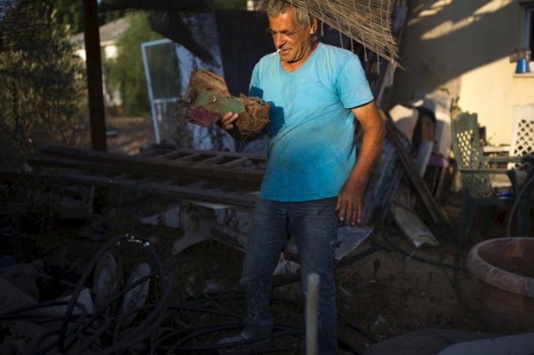 Israeli Nahum Hadad holds the remains of a rocket that he said landed near his former home in the Jewish settlement of Nisanit in Gaza, as he stands outside his home in Nitzan near Ashod, Israel August 6, 2015. A decade on from Israel's unilateral withdrawal of around 8,500 Jewish settlers from the Gaza Strip ,one of whom was Hadad, the legacy of that August 2005 "disengagement" still provokes angry debate in Israeli society. Picture taken August 6, 2015. To match Insight ISRAEL-GAZA/DISENGAGEMENT REUTERS/Amir Cohen