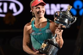 MEL6027 - Melbourne, Victoria, AUSTRALIA : Germany's Angelique Kerber gestures as she holds The Daphne Akhurst Memorial Cup as she celebrates after victory her women's singles final match against Serena Williams of the US on day thirteen of the 2016 Australian Open tennis tournament in Melbourne on January 30, 2016. AFP PHOTO / SAEED KHAN-- IMAGE RESTRICTED TO EDITORIAL USE - STRICTLY NO COMMERCIAL USE