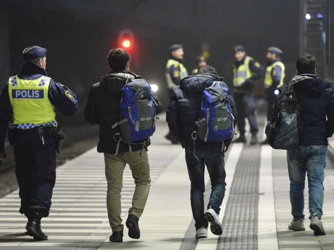 A picture made available 28 January 2016 shows a Swedish policeman escorting asylum-seeking refugees from a train at Hyllie station outside Malmoe, Sweden, 17 December 2015. Sweden is preparing for the expulsion of up to 80,000 people whose asylum bids have been rejected, a cabinet member said 28 January 2016. A record 163,000 people applied for asylum in Sweden in 2015, straining resources and capacity at reception centres and local municipalities. The increase of explusions will be likely only at the beginning of 2017 though, due to the backlog the Swedish Migration Agency was struggeling with. EPA/JOHAN NILSSON SWEDEN OUT
