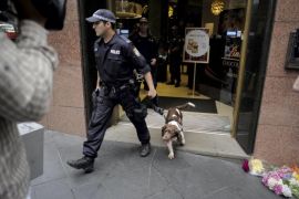 An Australian policeman and his bomb-sniffing dog exit the Lindt Cafe following a security sweep of the business in Sydney, December 15, 2015, on the first anniversary of the Sydney cafe siege. Australia marks one year since 18 people were taken hostage and two killed by lone gunman, Man Horan Monis, who was shot and killed by police, during a siege at the cafe in Sydney's Martin Place on December 16, 2014. REUTERS/Jason Reed