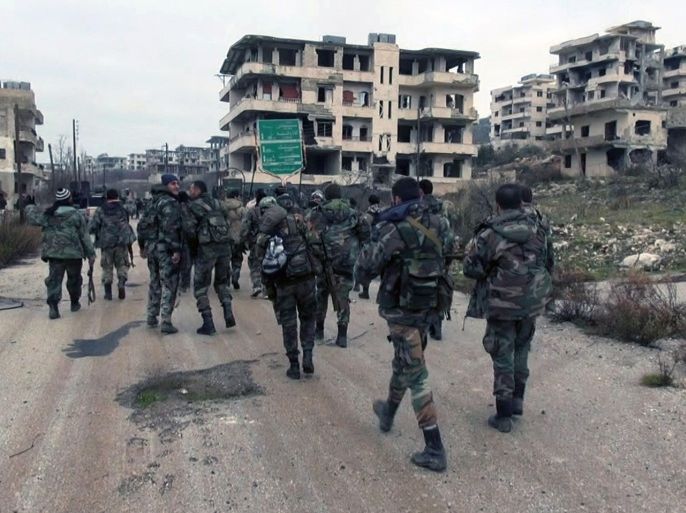 FILE - This Tuesday, Jan 12, 2016, file photo released by the Syrian official news agency SANA, shows Syrian government troops and allied militiamen walk inside the key town of Salma in Latakia province, Syria. Syrian peace talks scheduled to begin in a week are looking increasingly moot as regional tensions boil over and a string of battlefield victories by government troops further bolster the hand of President Bashar Assad, plunging the rebels into disarray. (SANA via AP, File)