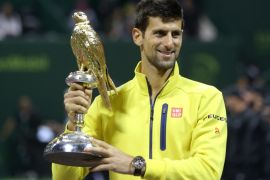 KJ08 - Doha, -, QATAR : Novak Djokovic of Serbia poses for a photo with his winning trophy after beating Rafael Nadal of Spain in the final of the Qatar Open tennis tournament on January 9, 2016, in Doha. AFP PHOTO / KARIM JAAFAR