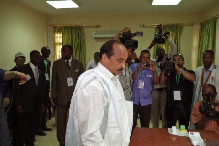 Mauritania's President Mohamed Ould Abdel Aziz, center, is seen before he cast his ballot during elections held in the city of Nouakchott , Mauritania, Saturday, June 21, 2014. Mauritanians voted Saturday to choose their next president, but with the major opposition parties boycotting, the incumbent seems certain to hold on to power. Mohamed Ould Abdel Aziz, who assumed power in a coup in 2008 and won elections a year later, has been a staunch ally of the West in facing the growing terror threat in West Africa.(AP Photo/Ahmed Mohamed)