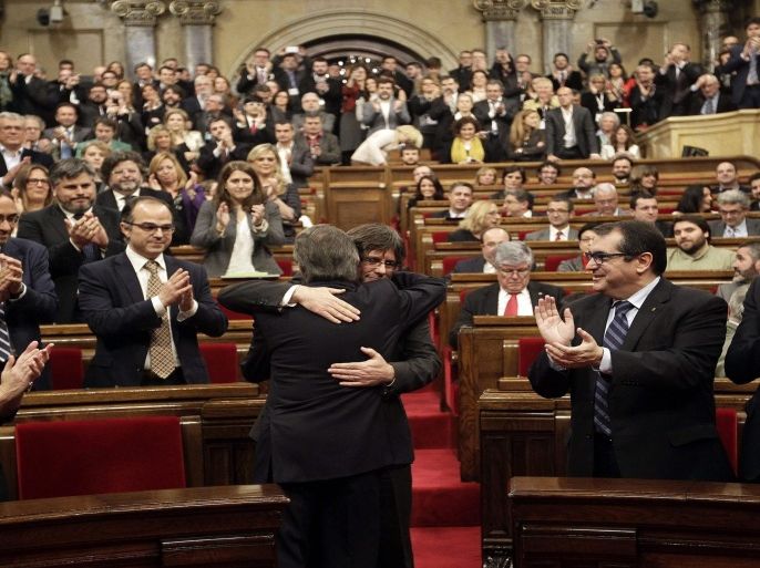 Catalonian acting President Artur Mas (front) embraces Gerona's Mayor Carles Puigdemont (C back) during the Puigdemont's vote of confindence in the regional Parliament in Barcelona, northeastern Spain, 10 January 2016. An alliance of pro-separatist parties in Catalonia on 09 January struck a last-minute deal to form a new regional government, after months of wrangling that threatened to undermine a fresh bid for independence from Spain. The Together for Yes (Junts pel Si) alliance, led by acting President Artur Mas, ceded to the demand of the leftist CUP party that Mas step down. In return, CUP entered into a coalition with Together for Yes. Carles Puigdemont, a former journalist and mayor of the Catalan town of Girona, will replace Mas as president, a position he held since 2010.