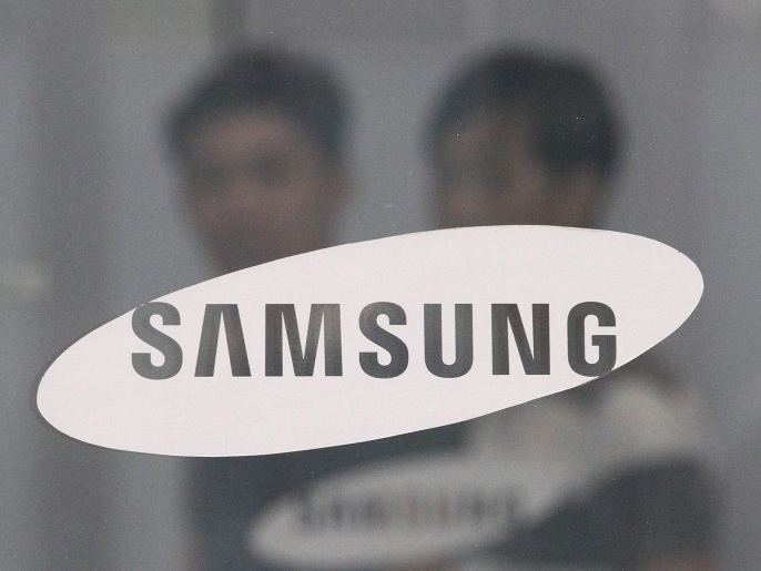 FILE - In this July 17, 2015 file photo, employees walk past a logo of Samsung Group at the head office of Samsung C&T Corp. in Seoul, South Korea. South Korea's financial regulator said Friday, Dec. 4, 2015 it has launched an investigation into possible insider trading by Samsung executives related to a contentious takeover deal. (AP Photo/Ahn Young-joon, File)