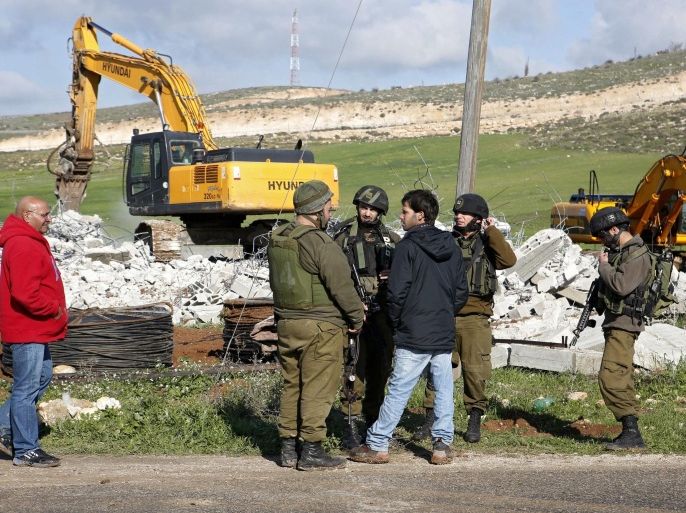 Israeli border policemen stand guard during the demolition of a house owned by the Palestinian Salem Abu Ayyash in the West Bank town of Dura, south of Hebron, 20 January 2016. Israel claims the home was built without the necessary permits which is located in area an under the Israeli adminstrative control.