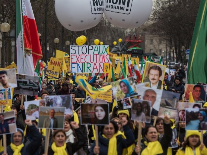A demonstrator holds up a sign reading "Stop Executions in Iran" as Iranian opposition protesters march in Paris during a rally to protest against the visit of the Iranian President, Hassan Rouhani, in France, Thursday, Jan. 28, 2016. Rouhani's visit to Paris is focused on renewing trade ties, but France also wants to draw in Iran's help in peacemaking in the region, notably in Syria and Yemen, and easing tensions with regional rival Saudi Arabia. (AP Photo/Zacharie Scheurer)
