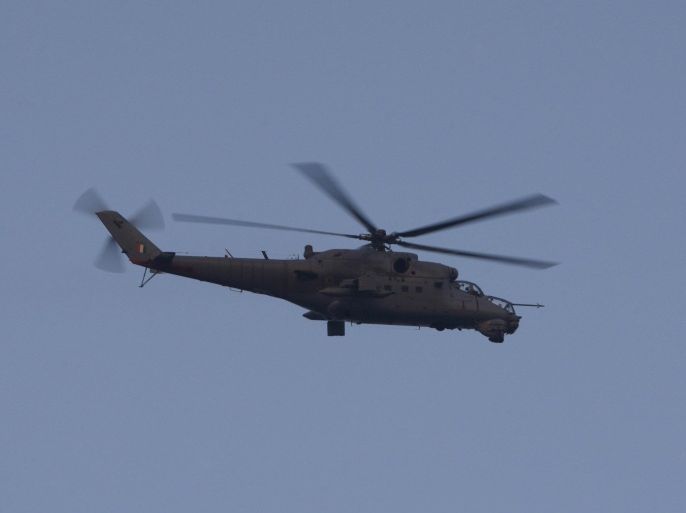 An Indian military helicopter keeps watch on the situation at the Indian airbase in Pathankot, 430 kilometers (267 miles) north of New Delhi, India, Saturday, Jan. 2, 2016. At least four gunmen entered an Indian air force base near the border with Pakistan on Saturday morning and exchanged fire with security forces, leaving two of them dead, officials said. (AP Photo/Channi Anand)
