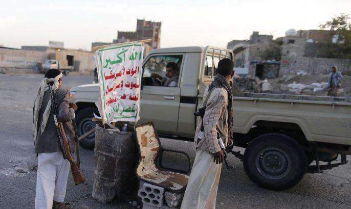 Shi'ite Houthi rebels man a checkpoint in Sanaa September 27, 2014. Shi'ite Muslim rebels attacked the home of Yemen's intelligence chief in Sanaa on Saturday, residents and security sources said, showing the fragility of a power-sharing accord that has failed to halt fighting in the capital. The banner reads "Allah is the greatest. Death to America, death to Israel, a curse on the Jews, victory to Islam". REUTERS/Khaled Abdullah (YEMEN - Tags: POLITICS CIVIL UNREST)