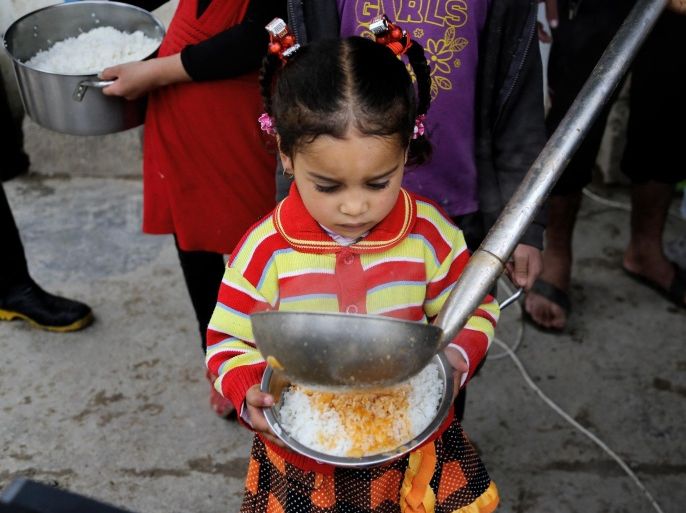In this Saturday, Jan. 23, 2016, a displaced girl waits for donated food at al-Takia camp in Baghdad, Iraq. More than 3 million Iraqis are displaced within the country by violence and instability. “They’ve lost their livelihoods, their jobs, and hunger and the inability to purchase food is a reality in their everyday life,” said Marwa Awad, with the World Food Program. (AP Photo/Karim Kadim)