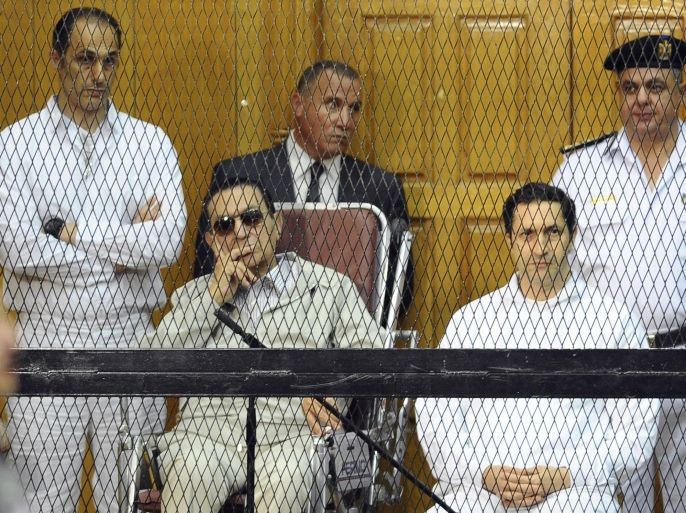 FILE - In this Sept. 14, 2013 file photo, former Egyptian President Hosni Mubarak, seated center left, and his two sons, Gamal Mubarak, left, and Alaa Mubarak attend a hearing in a courtroom in Cairo, Egypt. An Egyptian court on Monday, Oct. 12, 2015, has ordered the release of the sons of deposed autocrat Hosni Mubarak, Gamal, Mubarak's one-time heir apparent, and his brother Alaa, a wealthy businessman, after time served on a corruption conviction. Their father remains held in a military hospital. (AP Photo/Mohammed al-Law, File)
