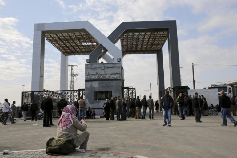 A Palestinian man and others wait outside the gate to cross the border to the Egyptian side at the Rafah crossing, in Rafah City, Gaza Strip, Thursday, Dec. 3, 2015. Egypt has reopened its border with the Gaza Strip in both directions for the first time in months. Thousands of Palestinians are lining up at Rafah border crossing to leave the isolated enclave. (AP Photo/Adel Hana)