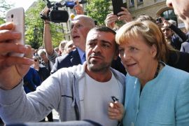 File photo of a migrant taking a selfie with German Chancellor Angela Merkel outside a refugee camp near the Federal Office for Migration and Refugees in Berlin, Germany, September 10, 2015. Time magazine named German Chancellor Angela Merkel its 2015 "Person of the Year" on December 9, 2015, noting her resilience and leadership when faced with the Syrian refugee crisis and turmoil in the European Union over its currency this year. REUTERS/Fabrizio Bensch/Files