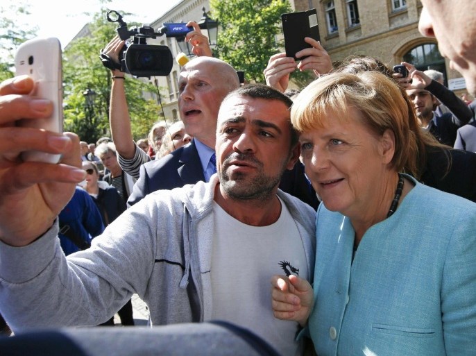 File photo of a migrant taking a selfie with German Chancellor Angela Merkel outside a refugee camp near the Federal Office for Migration and Refugees in Berlin, Germany, September 10, 2015. Time magazine named German Chancellor Angela Merkel its 2015 "Person of the Year" on December 9, 2015, noting her resilience and leadership when faced with the Syrian refugee crisis and turmoil in the European Union over its currency this year. REUTERS/Fabrizio Bensch/Files
