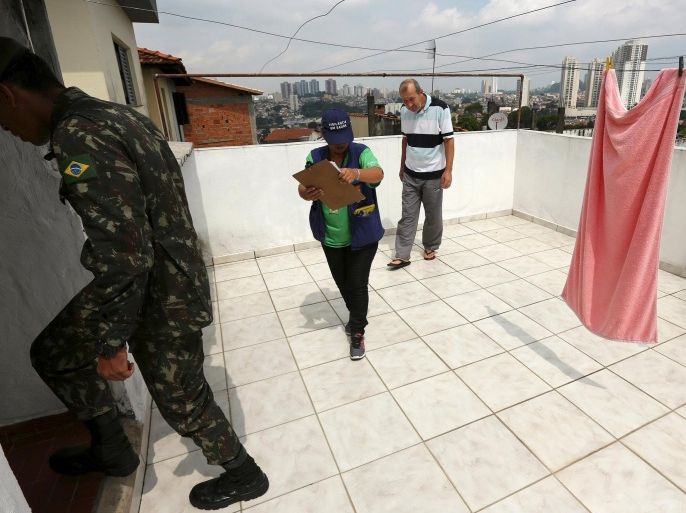 A soldier and a municipal worker inspect houses during an operation against the Aedes aegypti mosquito in Sao Paulo, Brazil, January 28, 2016. The Zika virus linked to severe birth defects in thousands of babies in Brazil - is spreading "explosively" and could affect as many as four million people in the Americas, the World Health Organization (WHO) said on Thursday. REUTERS/Rodrigo Paiva FOR EDITORIAL USE ONLY. NO RESALES. NO ARCHIVE.