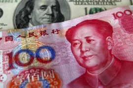 A yuan banknote is displayed next to a U.S. dollar banknote (back) for the photographer at a money changer inside the Taoyuan International Airport in this March 18, 2010 file photo. China's yuan softened to its softest level against the dollar since February 2011 on January 7, 2016 after the central bank set the guidance rate to its weakest since March 2011. REUTERS/Nicky Loh/Files