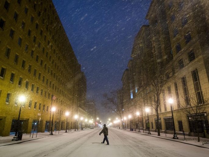 A pedestrian walks across a deserted E Street downtown as the first snow from a major blizzard hits Washington, DC, USA, 22 January 2016. Winter Storm Jonas is expected to dump more than two feet (61 centimeters) of snow in the Washington, DC region throughout the weekend.