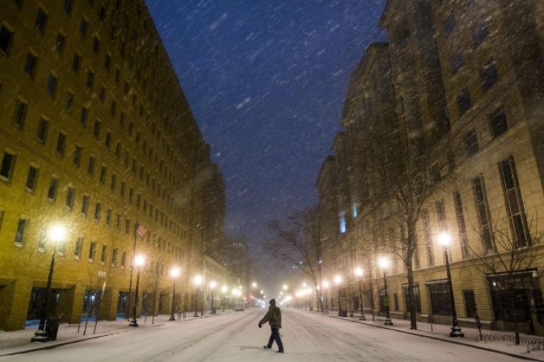 A pedestrian walks across a deserted E Street downtown as the first snow from a major blizzard hits Washington, DC, USA, 22 January 2016. Winter Storm Jonas is expected to dump more than two feet (61 centimeters) of snow in the Washington, DC region throughout the weekend.