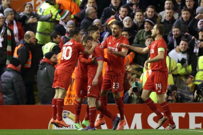 Liverpool's James Milner, center left, celebrates with teammates scoring his side's first goal from the penalty spot, during the Europa League round of 32 second leg soccer match between Liverpool and FC Augsburg in Liverpool, England, Thursday Feb. 25, 2016. (AP Photo/Clint Hughes)