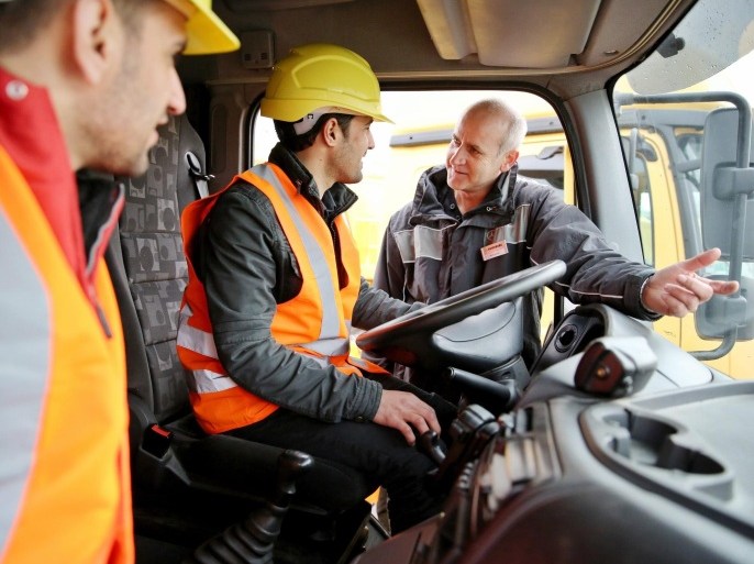 Driving instructor Sylvio Hanke (R) explains the cockpit of a 40-ton lorry to asylum seekers Mustafa al Amir (C) and Basel Jaghssi in Halle/Saale, Germany, 25 January 2016. The construction company Guenter Papenpurg intends to train around 100 refugees to help them become professional drivers. The company also plans to offer training for concrete workers, building machine operators and construction helpers to asylum seekers. 30 refugees are already currently completing an internship with a focus on 'Learning the German language'.