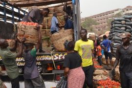 Workers unload tomatoes from a pick-up truck at a market in Enugu, Nigeria February 24, 2016. Nigeria is Africa's second largest tomato producer with 1.5 million tonnes of tomatoes annually, yet 45 percent of the produce will often perish. Tomato processing factories in the country are working to secure the market and keep out cheap imports, but lack of adequate facilities is making it difficult to produce tomato paste, a staple in the West African nation. Picture taken February 24, 2016. REUTERS/StringerEDITORIAL USE ONLY. NO RESALE. NO ARCHIVE