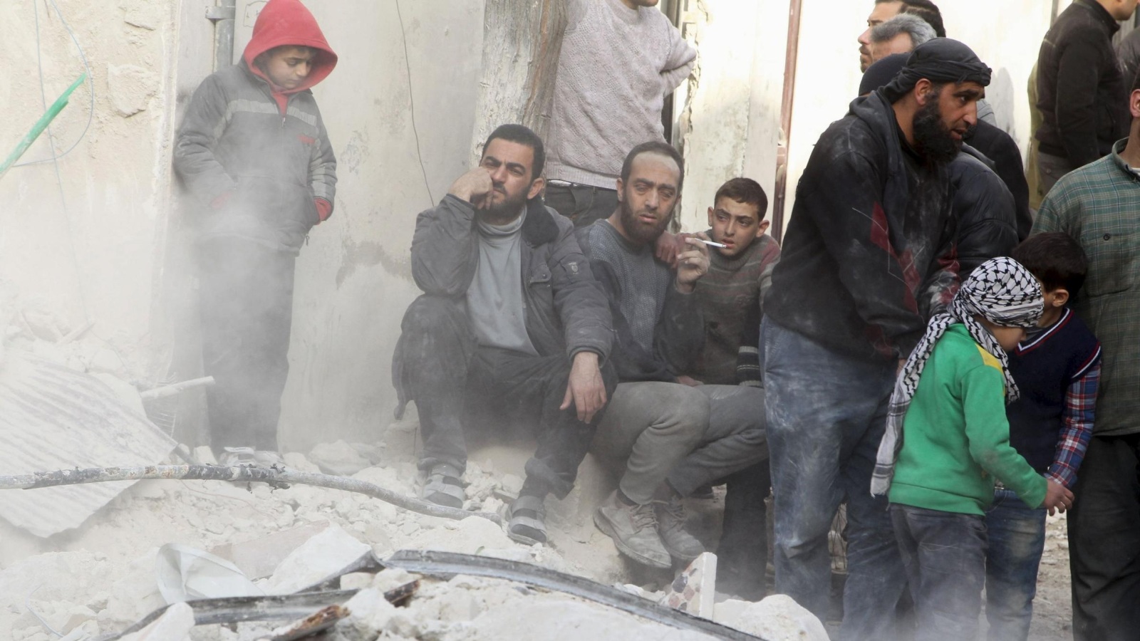 سوريون يعاينون الأضرار التي خلفتها غارات على حي القاطرجي بحلب (رويترز)